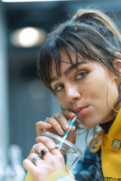 The girl holding a pen in yellow shirt
